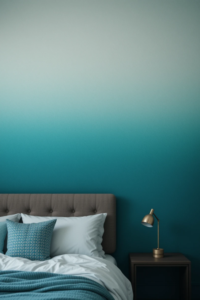 A bedroom with a teal ombre wall fading from dark to light, paired with minimalist furniture, soft lighting, and neutral decor for a dynamic look.